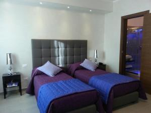 a bedroom with two beds with purple covers and a mirror at Domus Fontis in Rome +61 photos