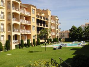 a large apartment building with a swimming pool in a park at Bertur Gran Reserva Comte Empuries in Empuriabrava