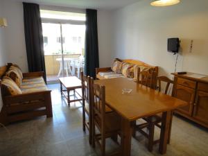 a living room with a wooden table and chairs at Bertur Gran Reserva Comte Empuries in Empuriabrava