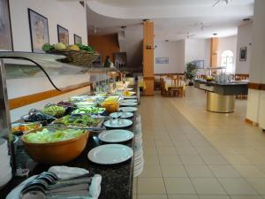 a buffet line with plates of food in a restaurant at Bertur Gran Reserva Comte Empuries in Empuriabrava