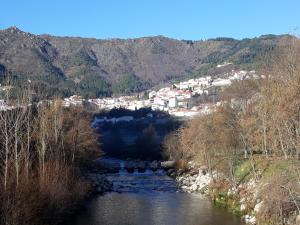 a view of a river with a town in the background at A Primeira Casinha do Mé-Mé in Manteigas