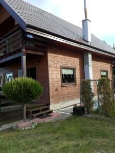una casa con un árbol delante de ella en Grabówka, en Nadole