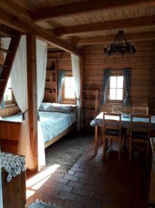 1 dormitorio con 2 camas y una mesa en una cabaña en Kiskemence Vendégház Szatta en Szatta