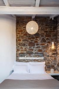 a bed in a room with a brick wall at Vathisthea in Kithnos +155 photos