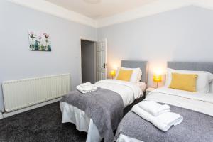 a bedroom with two beds with towels on them at Northwood Park View in Stoke on Trent