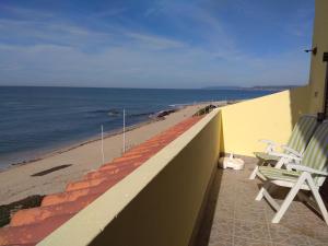 a balcony with two chairs and a beach at Largo do cruzeiro in Póvoa de Varzim