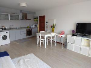 a kitchen with a table and chairs and a kitchen with a tv at Largo do cruzeiro in Póvoa de Varzim