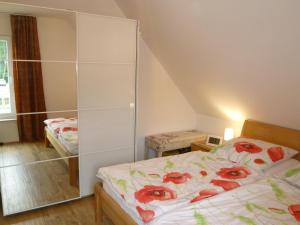 ein kleines Schlafzimmer mit einem Bett und einem Spiegel in der Unterkunft Kapitänsresidenz - Haus direkt am Wasser in Ückeritz + 20 Fotos