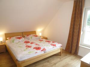 a bedroom with a bed with red flowers on it at Kapitänsresidenz - Haus direkt am Wasser in Ueckeritz