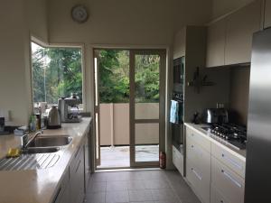a kitchen with a sink and a sliding glass door at Hahei Sea Vista (2) in Hahei