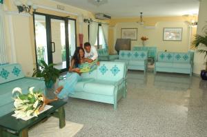 a man and a woman sitting on a couch in a living room at Residence Cala Liberotto in Cala Liberotto