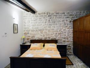 1 dormitorio con cama y pared de piedra en Apartment Primorac, en Stari Grad