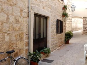 una bicicleta estacionada junto a un edificio de piedra con una puerta en Apartment Primorac, en Stari Grad