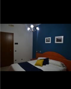 AquinoにあるAlbergo Ristorante San Tommasoの青いベッドルーム(黄色い枕付きのベッド付)