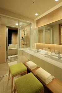 a bathroom with a sink and a large mirror at THE SINGULARI HOTEL & SKYSPA at UNIVERSAL STUDIOS JAPAN in Osaka