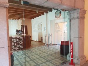 una puerta de cristal en una habitación con un reloj en la pared en Hotel Barroco en Puebla