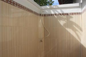 a shower with a hose on a tiled wall at Wani Bali Resort in Nusa Penida