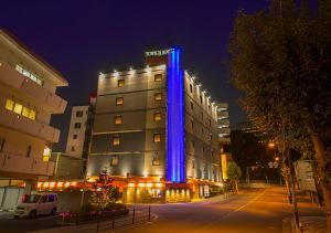 a hotel with blue lights on the side of it at Towers Hotel - Adult Only - in Osaka
