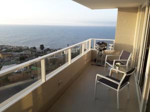 Un balcón con sillas y vista al mar. en Costa Horizonte 2, en Concón