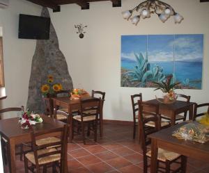 een eetkamer met tafels en een schilderij aan de muur bij Affittacamere Il Borgo in Francavilla Marittima