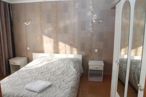 um pequeno quarto com uma cama e um espelho em Semey Hotel em Semei