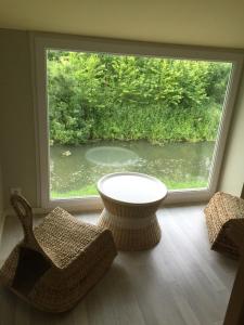 Cette chambre dispose d'une grande fenêtre avec des chaises et une table. dans l'établissement Relais Venise verte, à Coulon