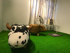 a room with a cow chair and a teddy bear at beNordic -8-10mins Tambun Water Park-10-14Pax in Ipoh +1 photo