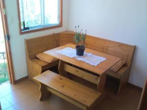 uma mesa e banco de madeira com uma planta em vasos em Cabaña 1 Neuling-Reñaca em Viña del Mar