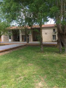 une maison avec des arbres devant une cour dans l'établissement Relais Venise verte, à Coulon