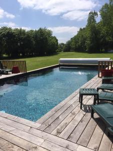 - une piscine sur une terrasse en bois avec un banc dans l'établissement Relais Venise verte, à Coulon