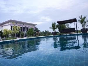 a large swimming pool in front of a building at Menam Resort in Nakhon Pathom