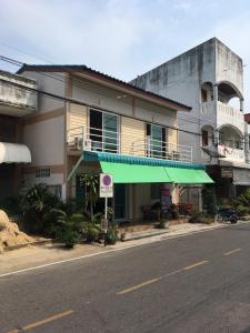 a building with a green awning on the side of a street at Y&N House in Prachuap Khiri Khan