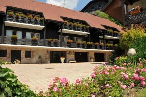 a building with potted plants on the balconies and flowers at Auberge Du Roselet in Duingt