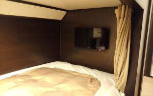 宮古市にあるホテル宮古ヒルズのベッドルーム1室(ベッド1台、壁掛けテレビ付)