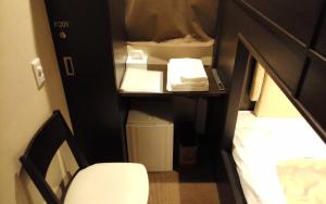 Mały pokój z łóżkiem i biurkiem ze stołem i krzesłem w obiekcie Hotel Miyako Hills w mieście Miyako