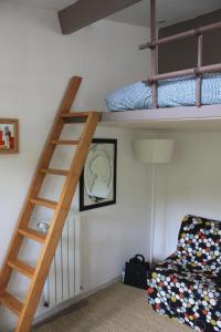 - un lit superposé avec une échelle et une chaise dans une chambre dans l'établissement Le Merle Rose, à Toulouse