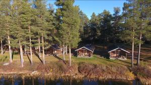 a group of cottages in the woods next to a lake at Camp Gielas, Arvidsjaur in Arvidsjaur