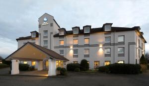 a large building with a clock on top of it at Best Western Hotel Cologne Airport Troisdorf in Troisdorf