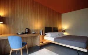 a bedroom with a bed and a desk and a chair at Hotel Clocchiatti Next in Udine