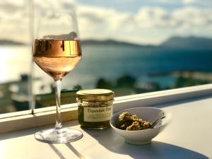 
a glass of wine next to a plate of food at Hôtel Les Voiles in Toulon
