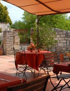 a table and chairs under an umbrella on a patio at chambres "gard'échoise" in Barjac