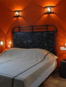 a bed in a room with two lights on the wall at chambres "gard'échoise" in Barjac