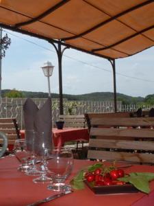 uma mesa com copos de vinho numa toalha de mesa vermelha em chambres "gard'échoise" em Barjac