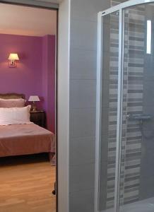 uma porta de duche em vidro num quarto com uma cama em chambres "gard'échoise" em Barjac
