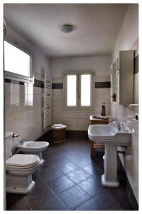 een badkamer met 2 wastafels en 2 toiletten bij La Casa sul Molo in Viareggio