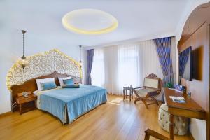 a bedroom with a bed and a table and a chair at Kaya Ninova Hotel in Mardin +48 photos