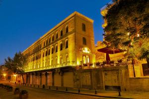a large building with a clock tower at night at Kaya Ninova Hotel in Mardin