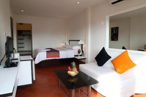 a living room with a white couch and a bed at Swiss Villas Panoramic - SHA Certified in Patong Beach