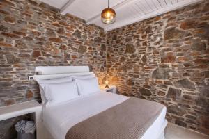 a bedroom with a bed in a brick wall at Vathisthea in Kithnos
