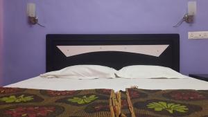 a white bed with a black headboard with two pillows at Asia Lodge Near Railway Station in Aurangabad +32 photos